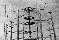 多摩送信所の円筒型送信塔。木造の組み立て塔によって空中線を支えている。送信設備や宿舎を中心とする5棟からなる局舎が点在し、その北・東・南の尾根の山林中に6基の発信用アンテナを張り巡らせていた。