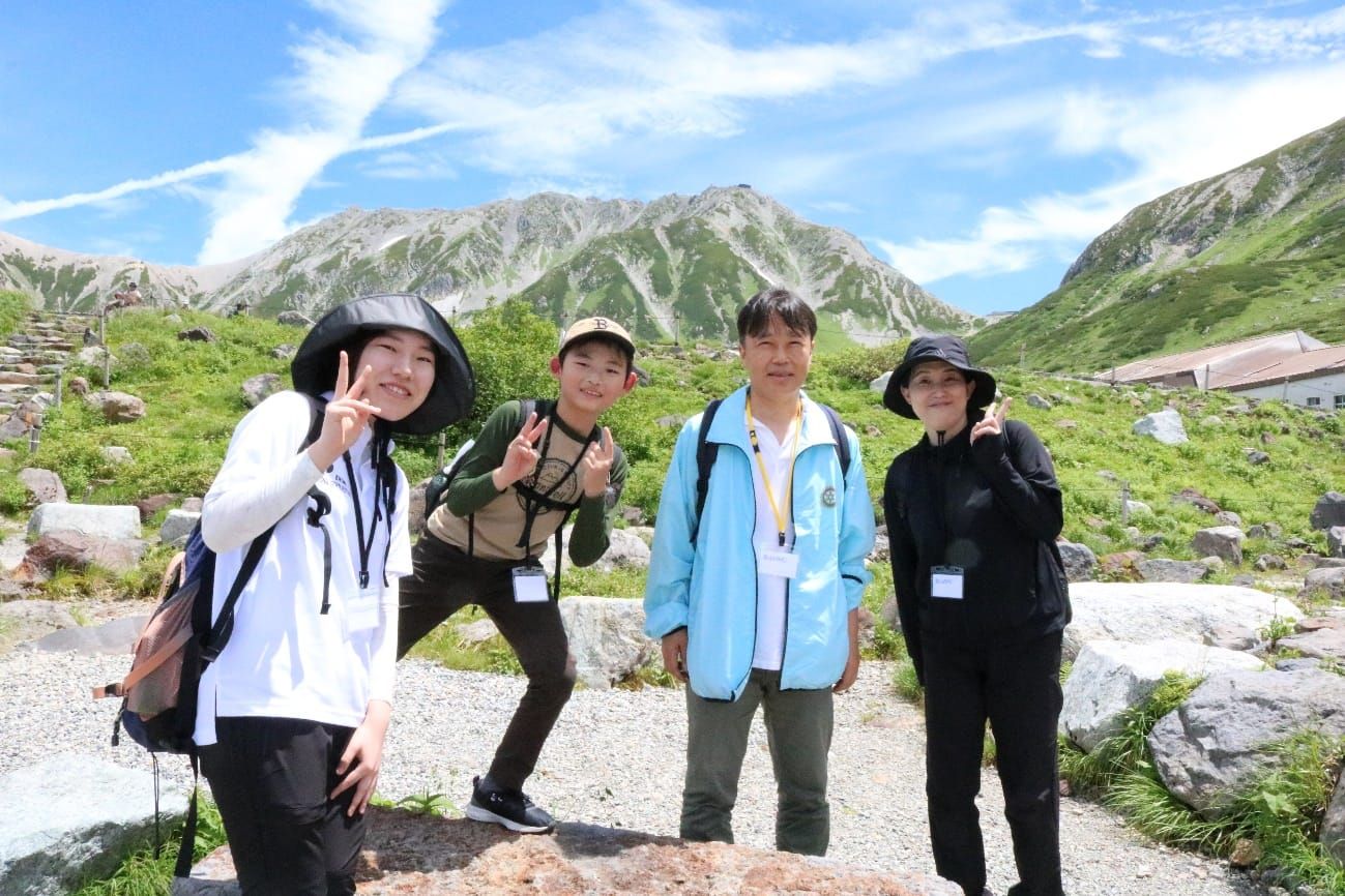 外来植物の除去作業を終え、雄大な立山連峰をバックに記念撮影