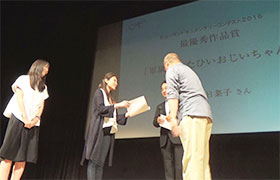 大阪市阿倍野区民センターで最終作品賞を表彰される松本さん（中央）、和田さん