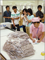 製品１つ１つを金属検知器にかけ、折れ針など異物が入っていないかどうか、丁寧に検品していく